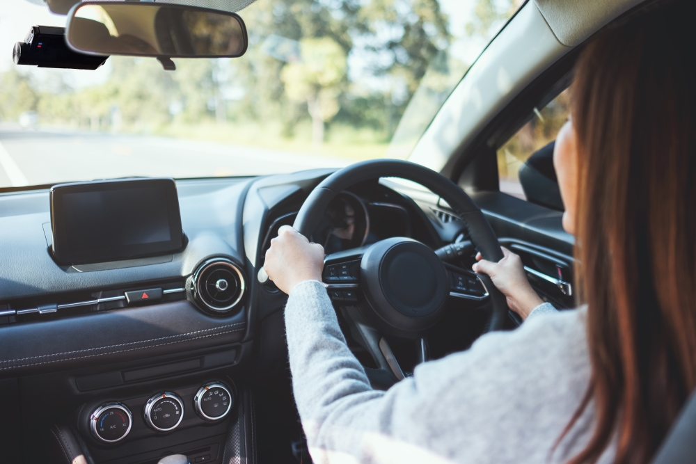 Driver holding steering wheel inside a car
