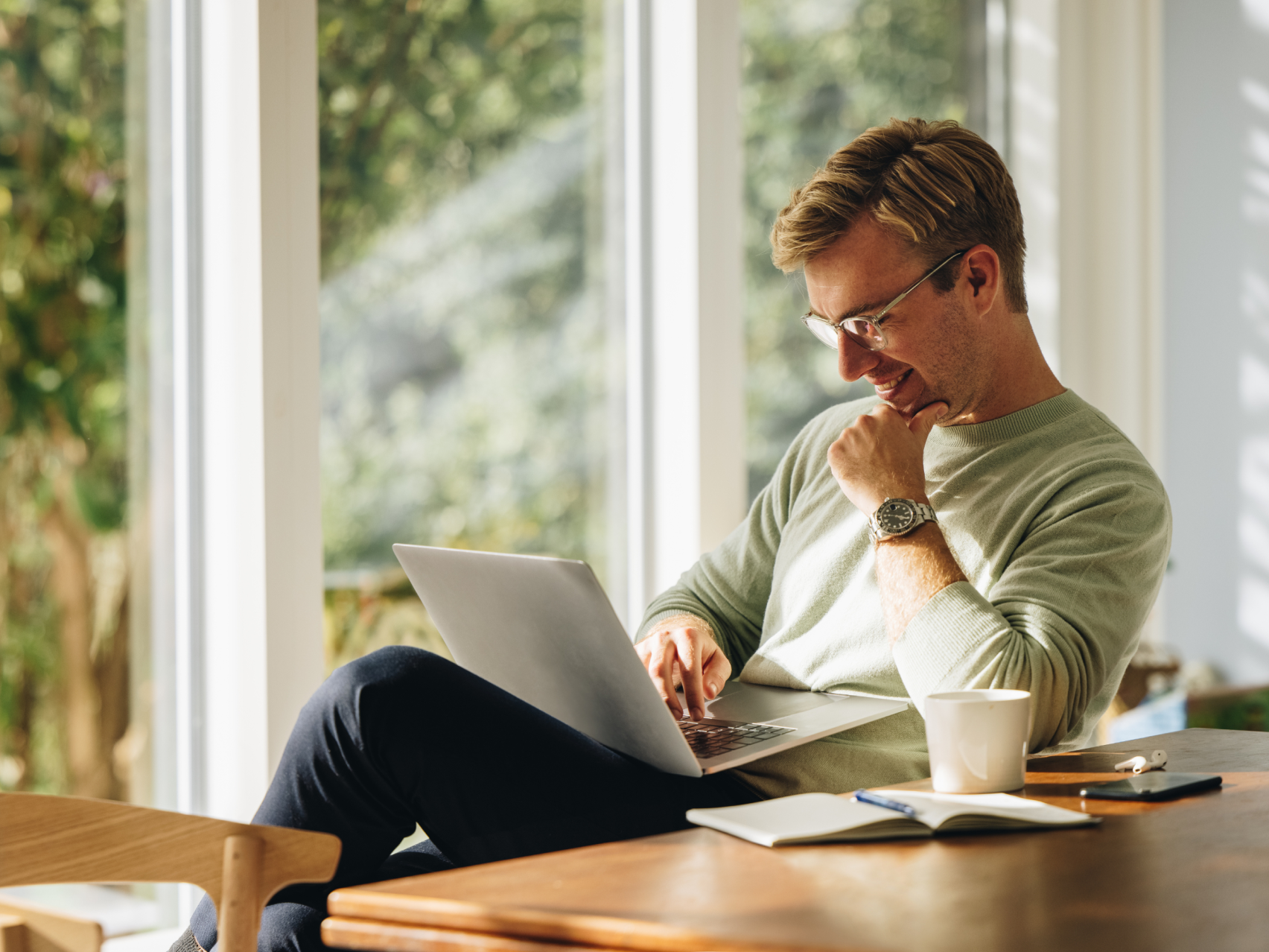 Person in green sweater using laptop