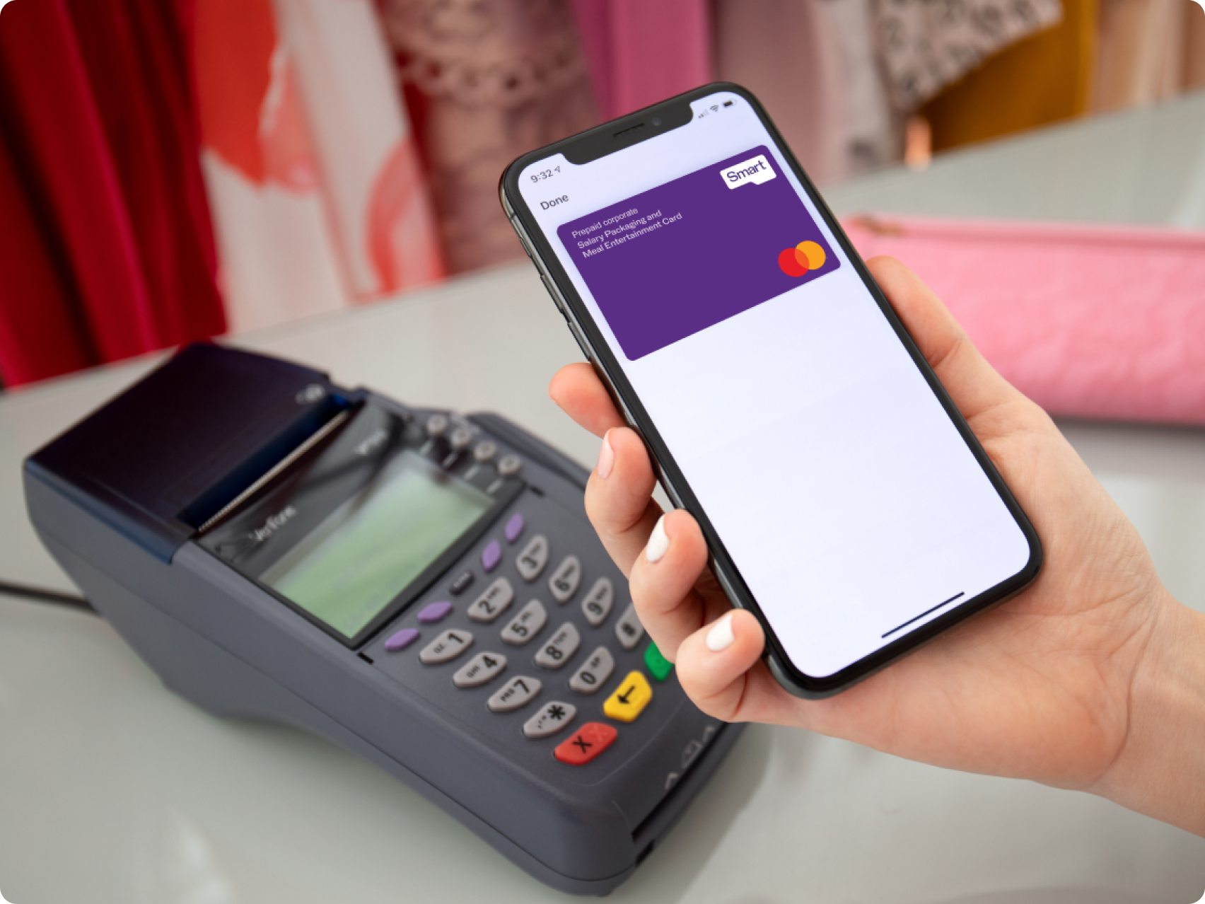 Person holding a digital salary packaging card up to EFTPOS machine to pay