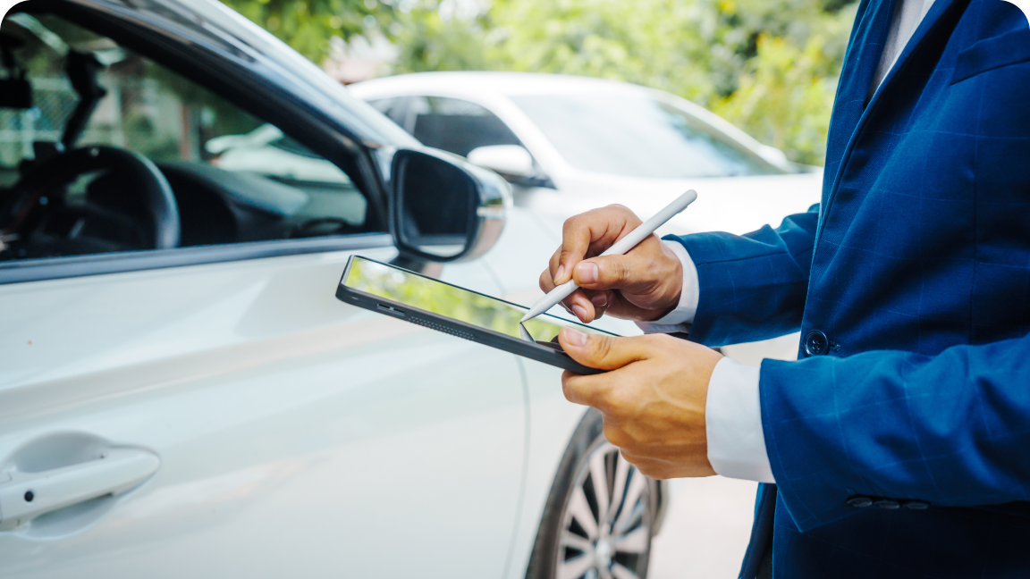 Person inspecting a white car using a tablet