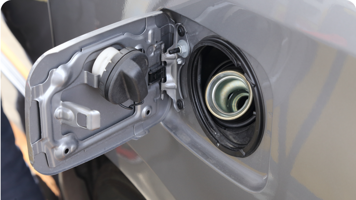 Open fuel door showing cap and filler neck